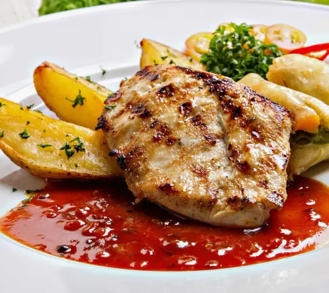 Grillowany kurczak z pieczonymi ziemniakami i sosem, idealny posiłek w jednej z restauracji w Bukowinie Tatrzańskiej.
